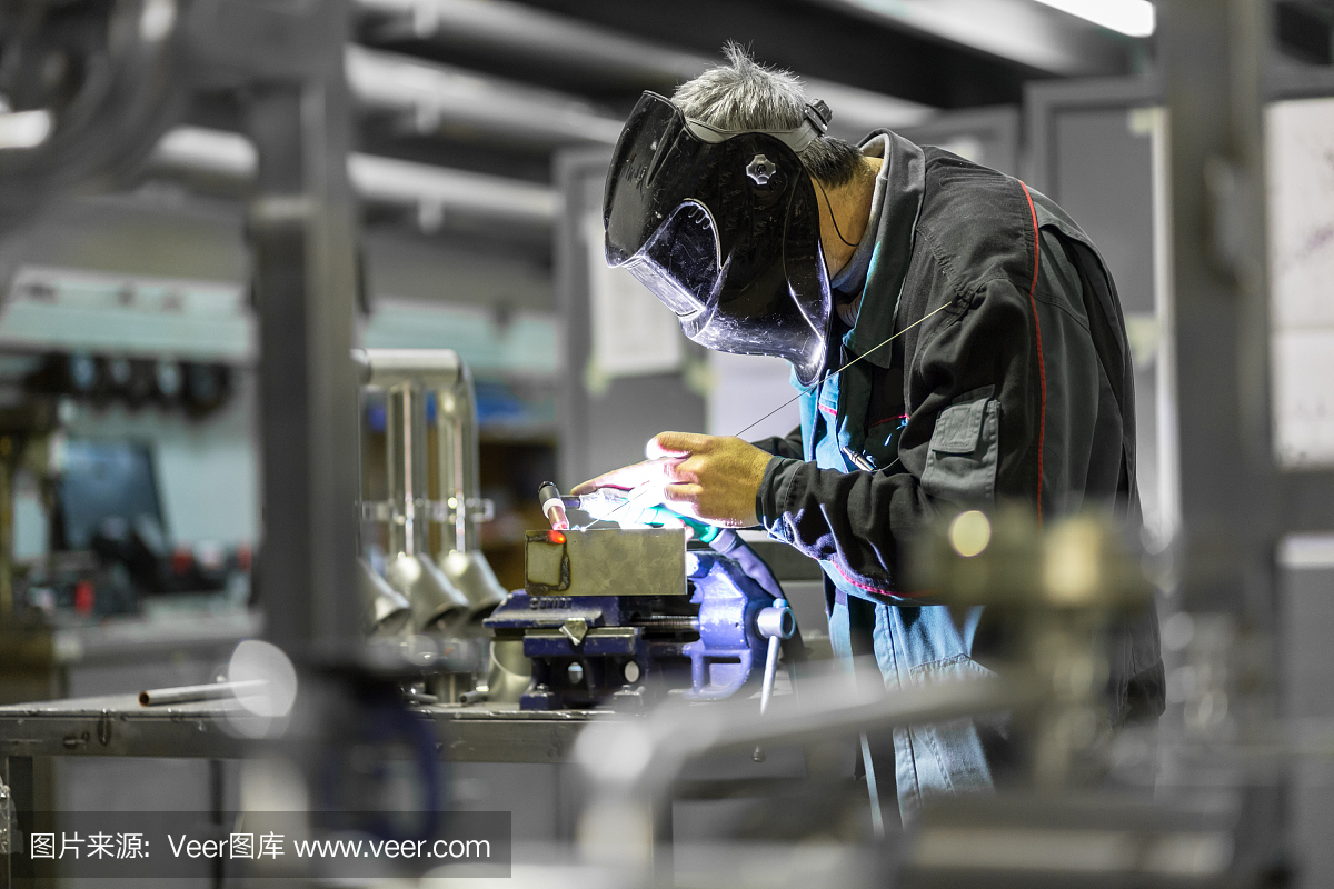 工业工人在金属工厂焊接。